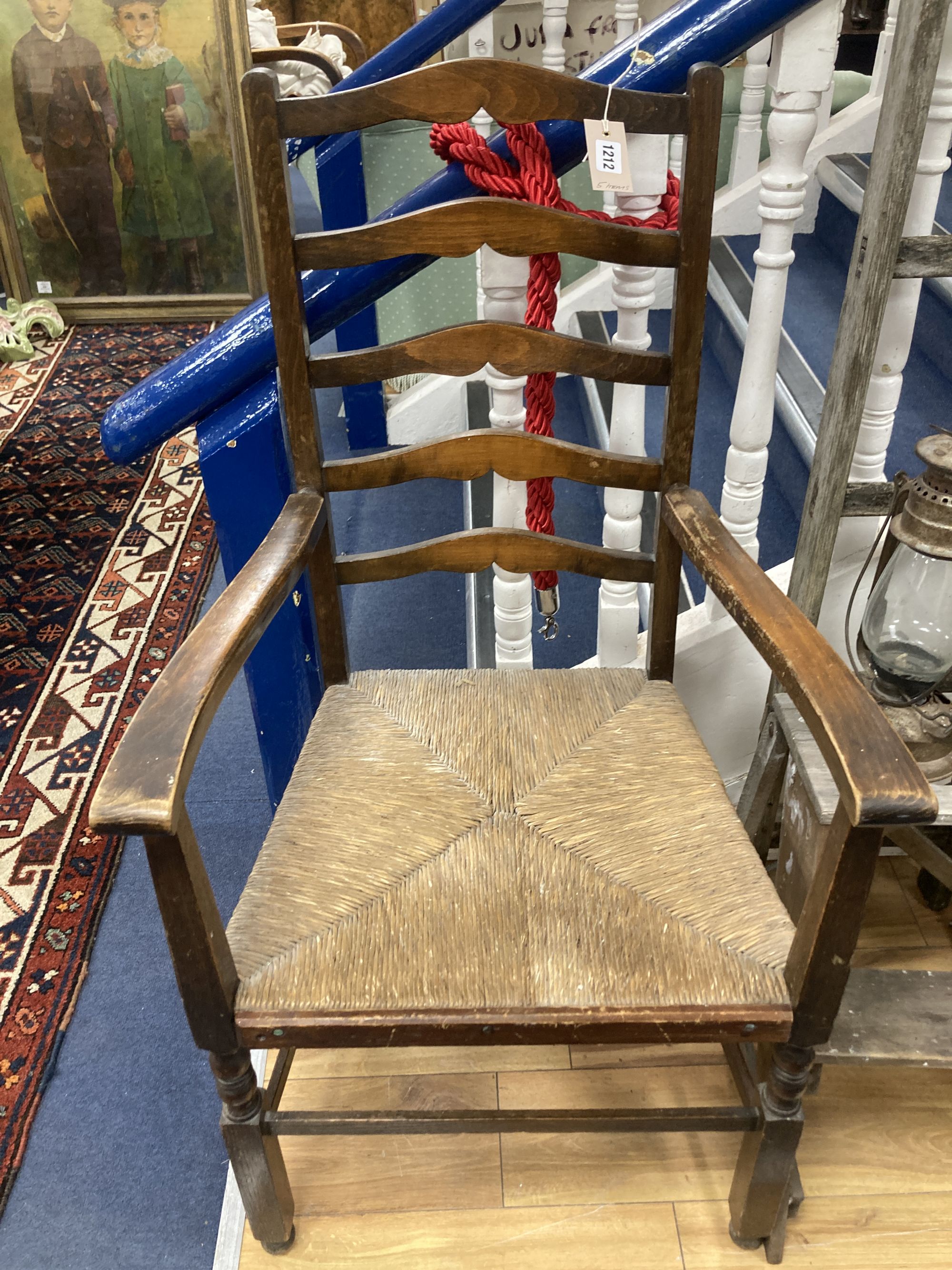A rush seated beech elbow chair, a vintage five tread step ladder, a similar pine step stool and two oil lamps
